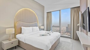Ein modernes Hotelzimmer mit einem großen Bett, einem Nachttisch mit Lampe, einem Flachbildfernseher und einem großen Fenster mit Blick auf die Stadt.
