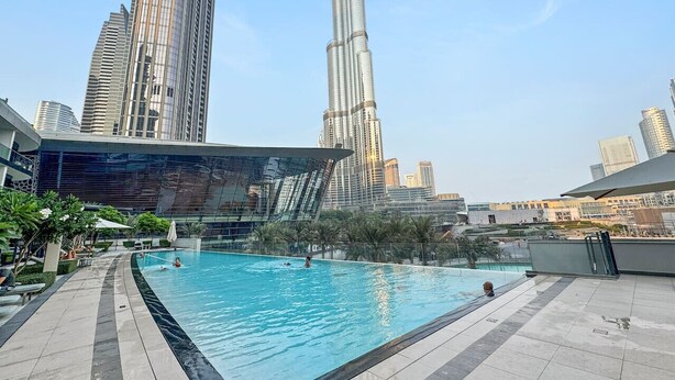 Ein Pool im Freien mit einer Skyline im Hintergrund, darunter hohe Gebäude.