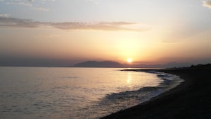 A beach with the sun setting over the water, a clear sky, and distant mountains. - Holiday Home 'Monte Azul' with Private Pool, Wi-Fi and Air Conditioning (Benajarafe)