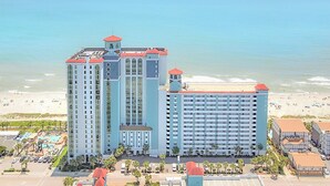 A large hotel with multiple towers, a pool area, and a beach view. - The Caribbean Resort and Villas #327 (Myrtle Beach)