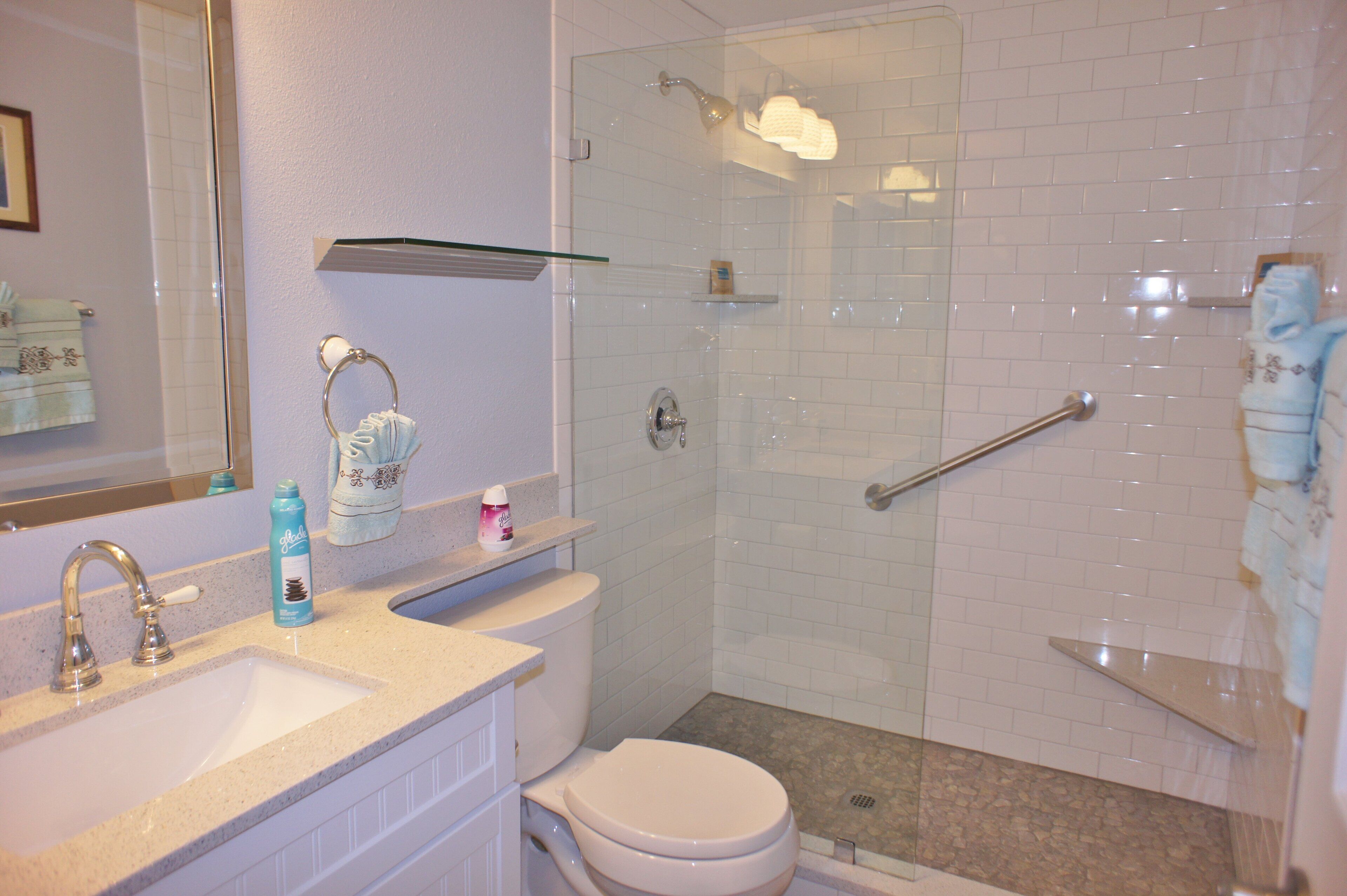 Une salle de bain équipée d’un lavabo, de toilettes et d’une douche à parois de verre.