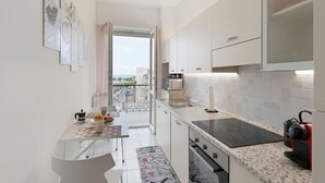 Eine moderne Küche mit Essbereich, Blick durch die Tür und einem Balkon.