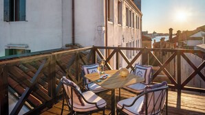 Eine Terrasse mit Tisch und Stühlen mit Blick auf Stadt und Wasser.