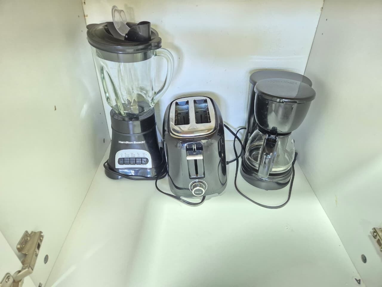 A kitchen counter with a blender, toaster, and coffee maker.
