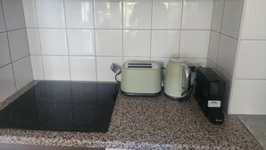 A kitchen with a black induction cooktop, two Breville toasters, and a Breville coffee maker. - West Perth apartment. Walking distance to CBD, King's Park and Public transport. (West Perth)