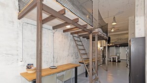 Eine rustikale Küche mit Holzbalken, einer Leiter und einem Holztisch mit Stühlen.