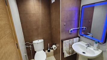 Een haardroger, handdoeken, zeep, toiletpapier