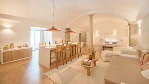 A spacious living area with a kitchen, dining area, and seating space. - Pátio do Tempo (Évora)