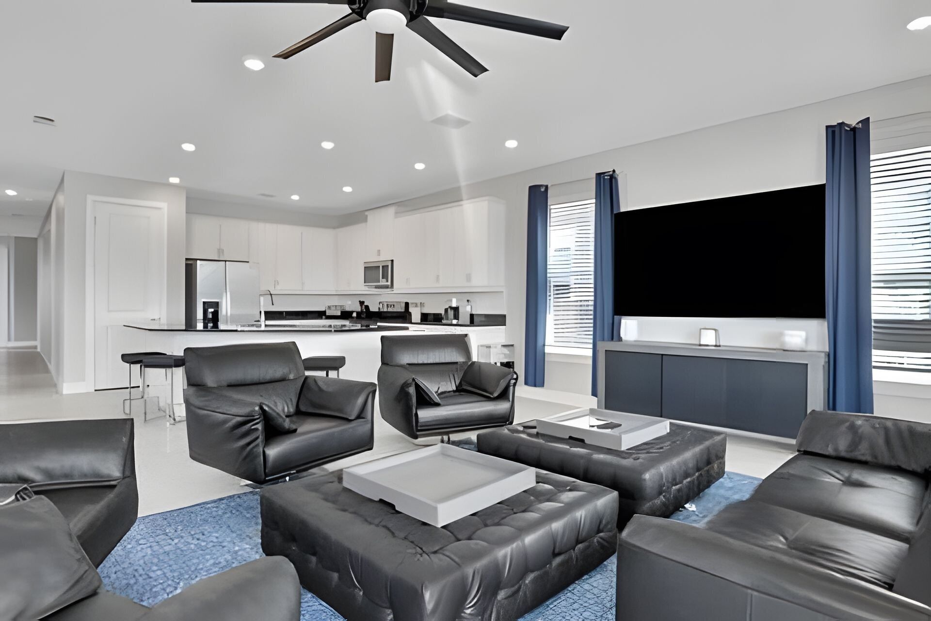 A modern living room with leather sofas, a coffee table, and a TV.