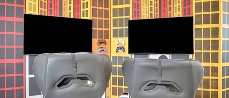 A 3D animated cityscape with colorful buildings and two gray, futuristic chairs facing each other.