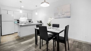 Una cocina moderna con armarios blancos, una isla central e iluminación colgante.