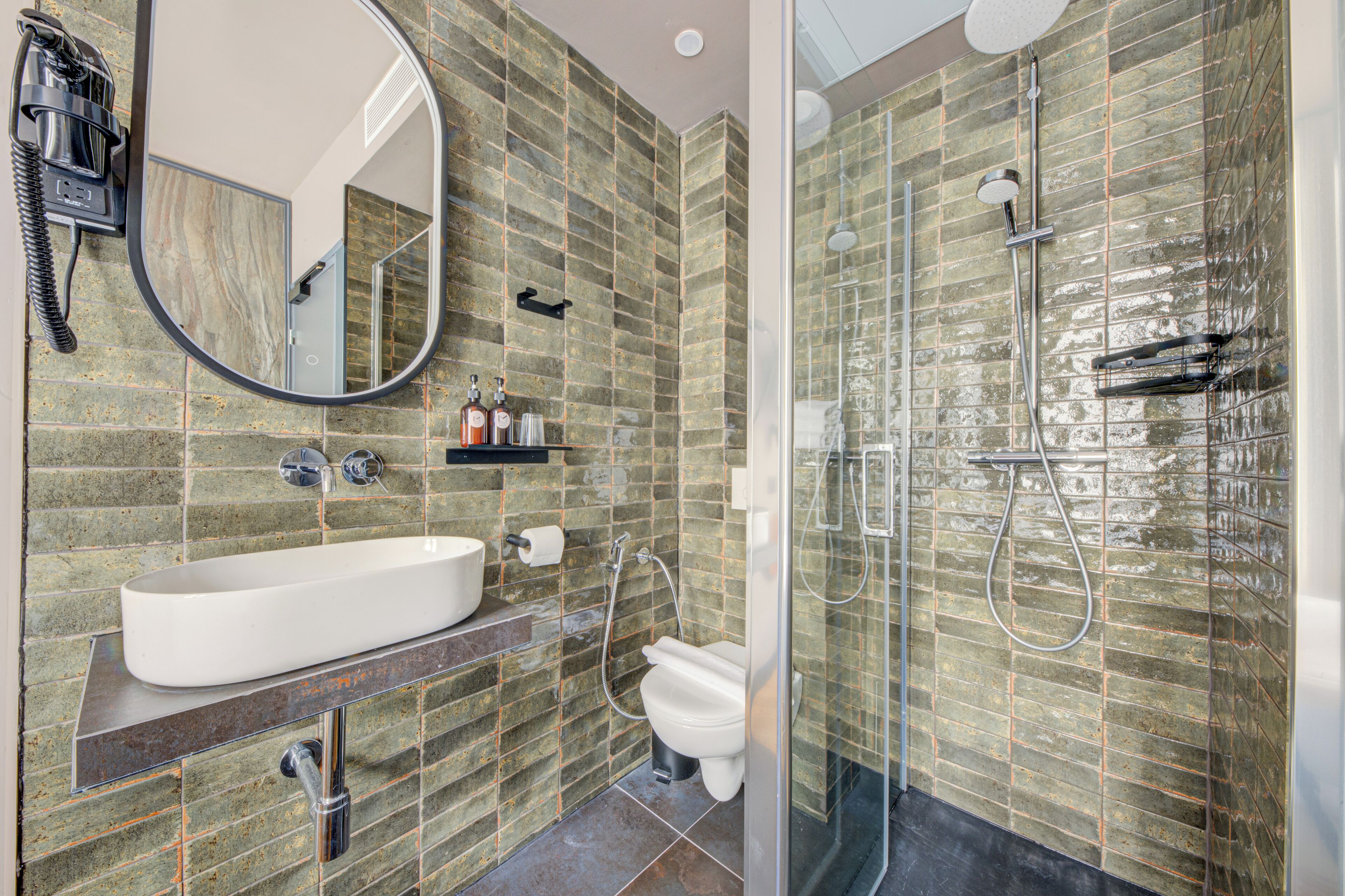 Une salle de bain avec un grand lavabo, des toilettes et un espace douche.