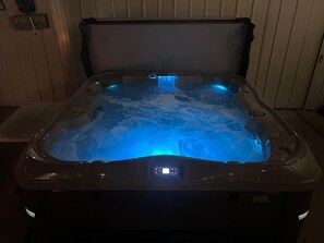 Un jacuzzi con panel de control digital y función de luz azul.