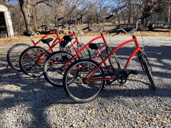 Tres bicicletas rojas estacionadas sobre un camino de grava.