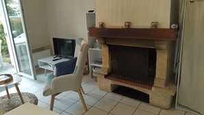 Una sala de estar con chimenea, televisor y comedor.