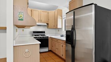 Een koelkast, een microgolfoven, een oven, kookgerei, borden en bestek