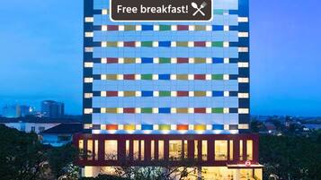 A multi-story hotel with a distinctive facade featuring a grid of illuminated panels.