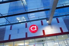Un bâtiment dont la façade est ornée d’un grand logo rouge en forme de « a ».