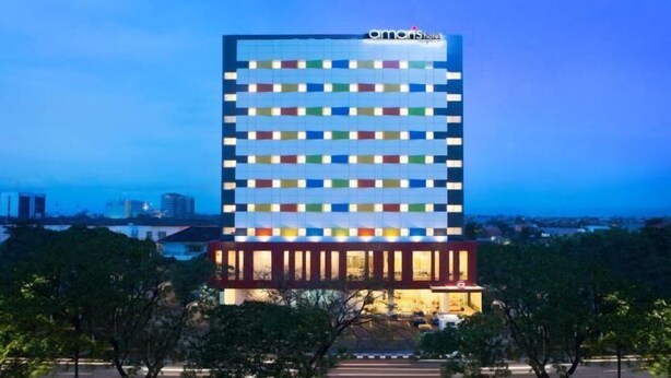 A multi-story hotel with a modern design, featuring a series of windows and a prominent entrance. - Amaris Hotel Pettarani - Makassar (Panakkukang)