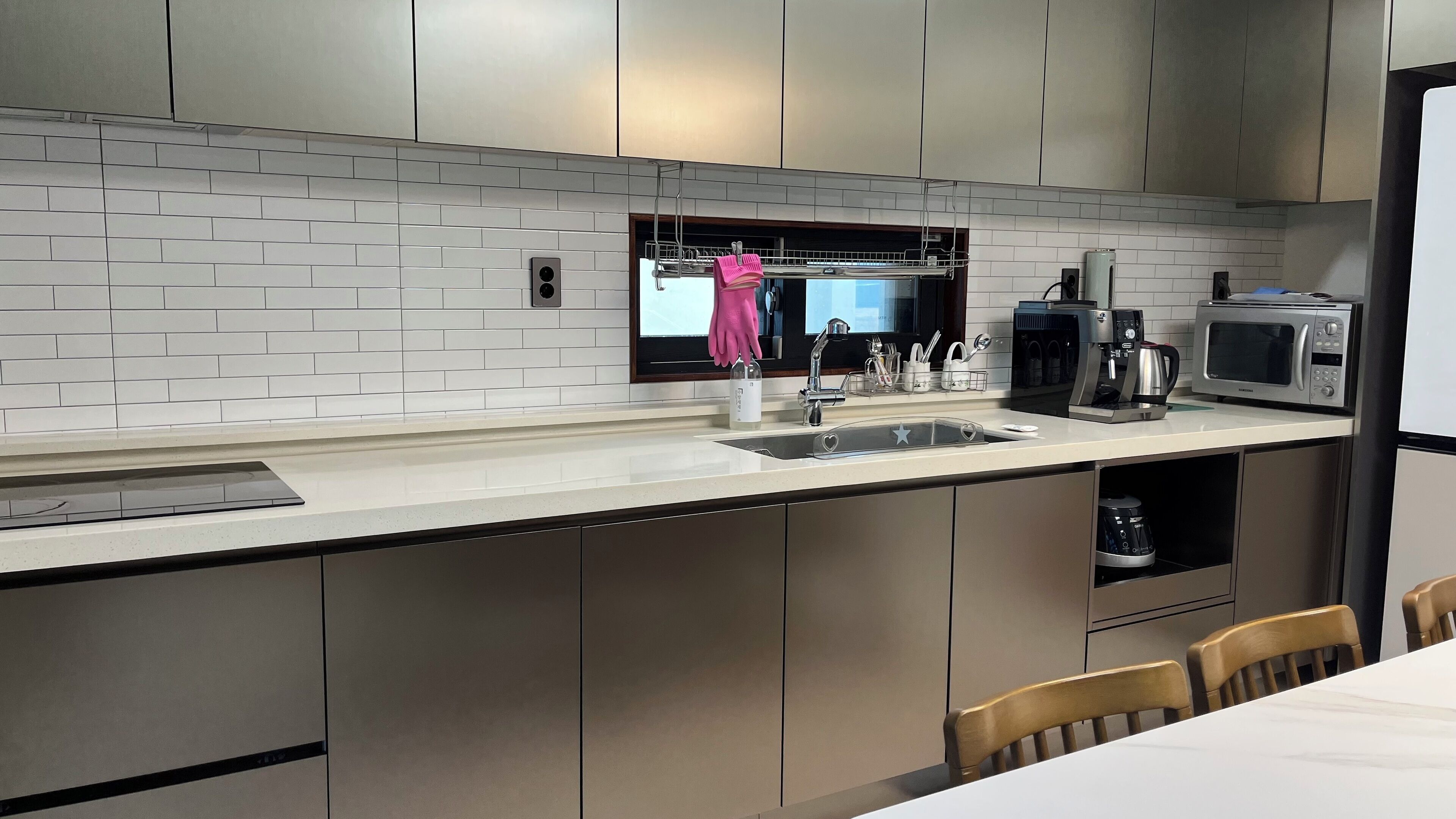 Una cocina moderna con salpicadero de azulejos blancos, electrodomésticos de acero inoxidable y horno empotrado.
