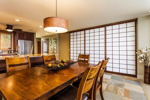 Ein traditioneller japanischer Speisesaal mit Holztisch, Stühlen und einer dekorativen Obstschale.
