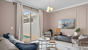 Un salon moderne avec un canapé, une table basse et un tableau accroché au mur.