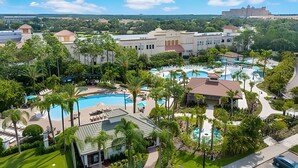 A resort with multiple swimming pools, lush greenery, and a large building in the background. - Vista Cay 4BR Condo w/ Balcony & Foosball Fun (Orlando)