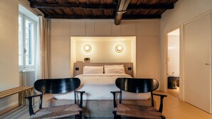 Une chambre à coucher avec un lit, deux chaises, une fenêtre et une porte.