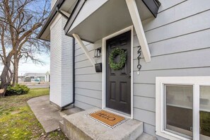 A house with a dark front door, a welcome mat, and a wreath on the door. - Spokane Apartment - North Atlantic Suite (Spokane)