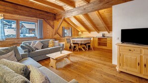 Un interior de madera con un sofá, una mesa de comedor y un televisor.