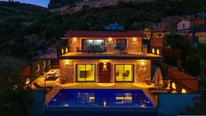 A two-story house with a swimming pool, stone exterior, and a balcony with outdoor seating. - Villa Elvin in Slamlar K y (Kaş)