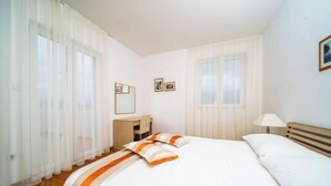 Une chambre d’hôtel avec un lit, un bureau, une chaise et une lampe.