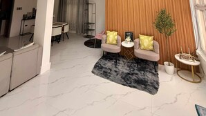 A spacious living area with a high ceiling, a dining area, and a kitchen.