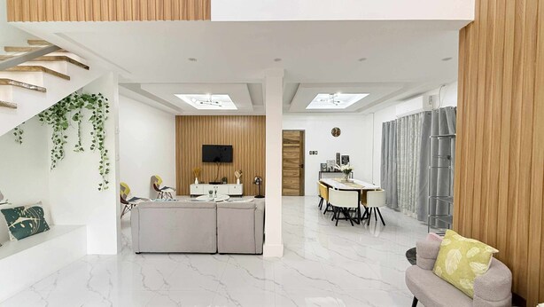 A modern living space with a central island, a dining area, and a sofa.