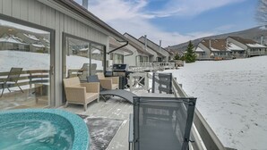 En moderne bygning med store vinduer, et overdækket udendørsområde med siddepladser og en swimmingpool.