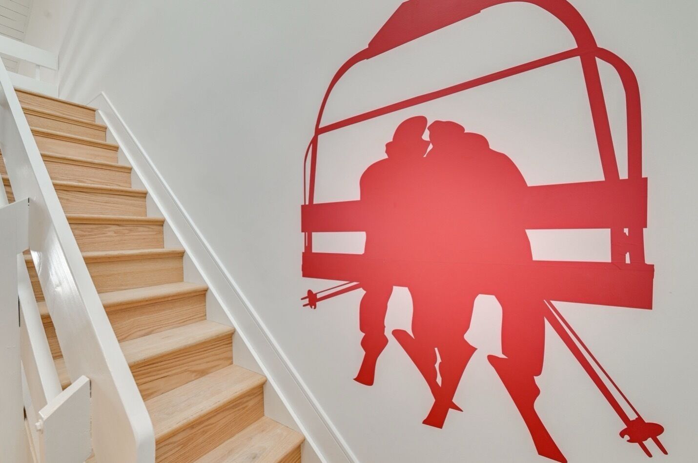 Een trap met een rode silhouet van een skilift op de muur.