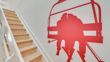 Een trap met een rode silhouet van een skilift op de muur.