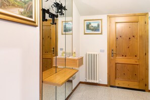 A room with a wooden bench, a mirror, a radiator, and two doors. - Apartment 'Casa Vacanze Dal Castelin' with Mountain View, Balcony & Air Conditioning (Sondrio)