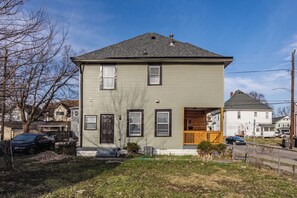 A two-story house with a front porch, a garage, and a driveway.