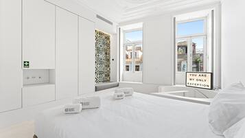 Tabla de planchar con plancha, internet y ropa de cama