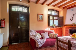 A cozy living room with a red sofa, a fireplace, and a television. - Casa de Aldea 'Blanca' in the Heart of Asturian Mountains (Vegarrionda)
