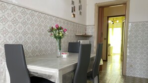 A dining area with a table, chairs, a vase with flowers, and a radiator. - La Casa Nel Verde - Two Bedroom Apartment, Sleeps 4 (Mede)