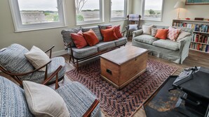 A cozy living room with a sofa set, a wooden chest, and a bookshelf. - The Dairy (Newton Stewart)