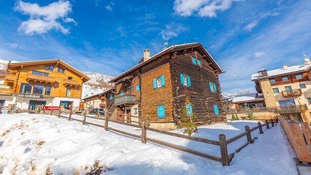 A wooden chalet with a balcony, surrounded by snow and mountains. - Apartment 'Chalet San Valentino' with Mountain View, Shared Garden and Wi-Fi (Livigno)
