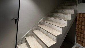 Una escalera de diseño moderno, una puerta con manija y un accesorio de iluminación en el techo.