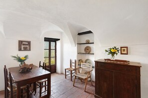 A dining area with a wooden table, chairs, and a cabinet.