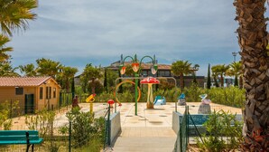 A playground with a slide, a climbing structure, and a bench. - Mobile Home for 6 with Private Terrace, Wi-Fi & Air Conditioning in Hyères (Hyères)