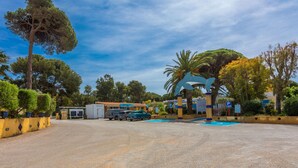 A parking lot with a building, trees, and a clear sky. - Mobile Home for 6 with Private Terrace, Wi-Fi & Air Conditioning in Hyères (Hyères)