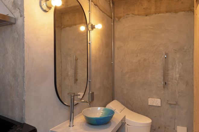Een badkamer met een grote spiegel, een wastafel en een toilet.