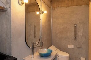 Un baño con un espejo grande, un lavabo y un inodoro.